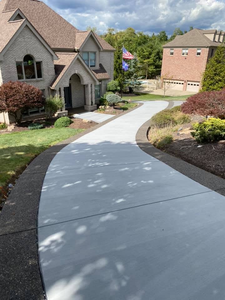 New broom-finish concrete driveway with exposed aggregate borders
